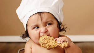 کودک در حال خوردن مرغ سوخاری